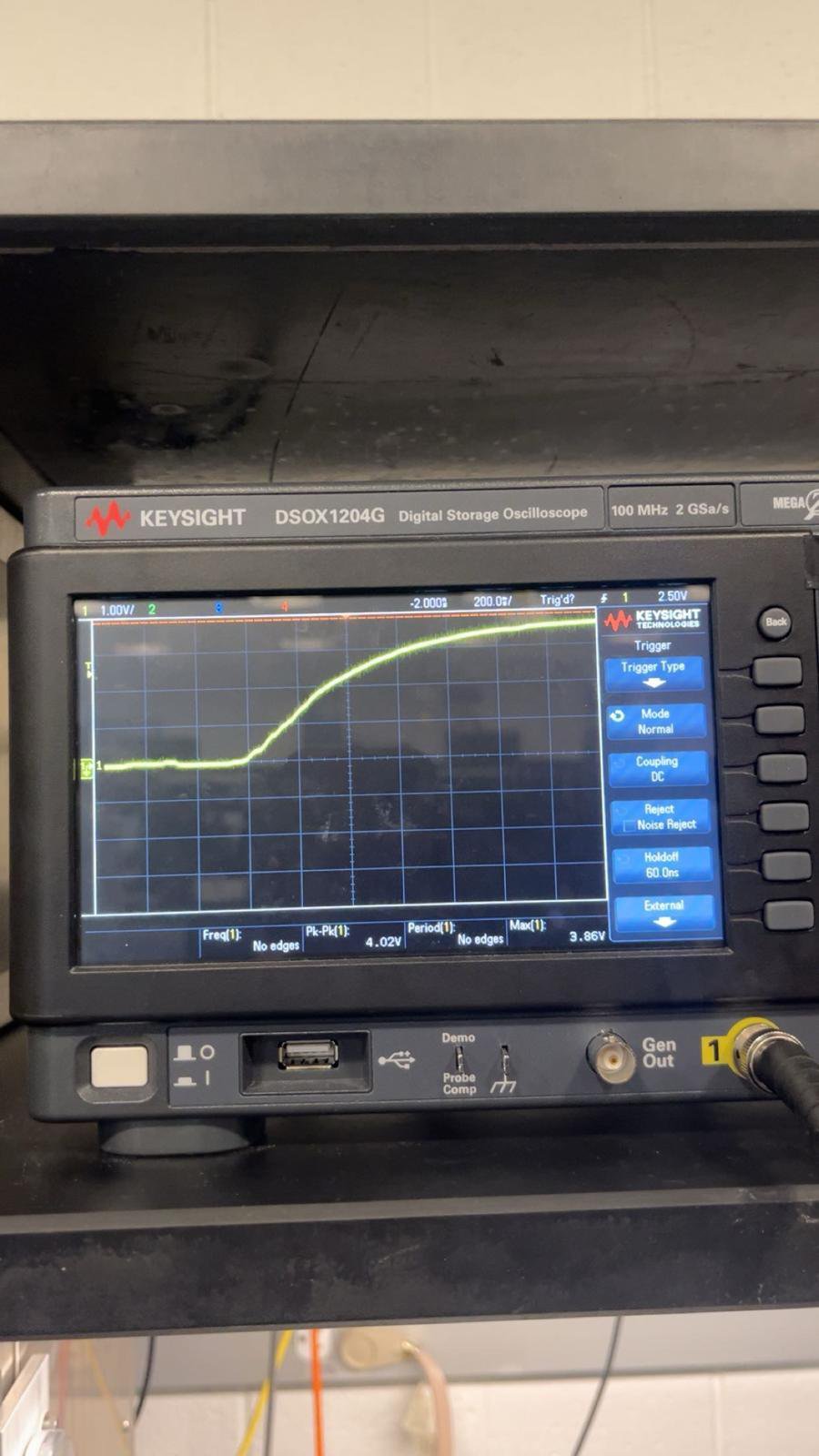 A benchtop oscilloscope displaying a captured trace during testing.